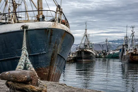 AI-generated illustration: A weathered fishing boat at an Argentine-style industrial quay.